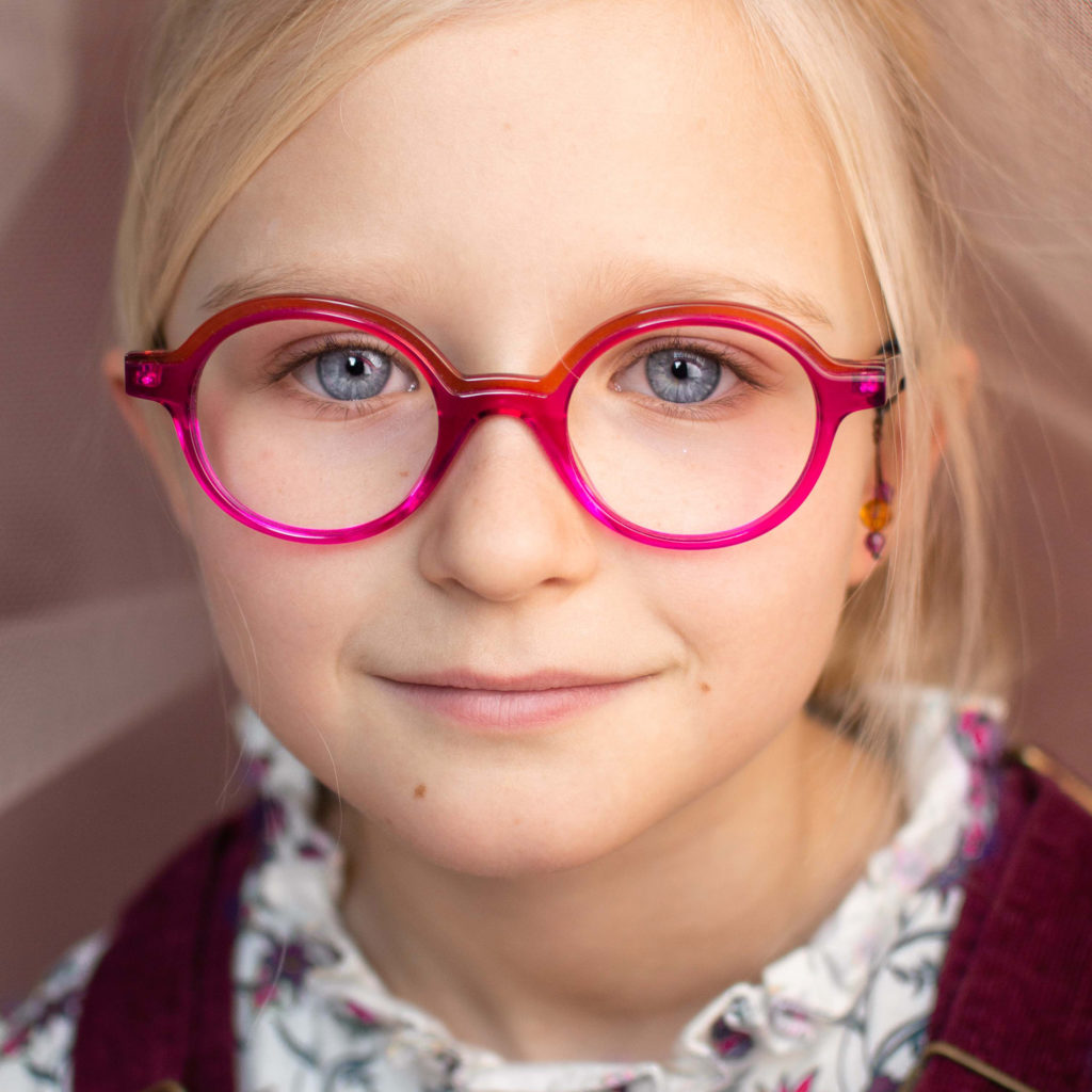 jeune fille portant des lunettes Tête à lunettes modèle 44 en acétate de couleur rose/rouge